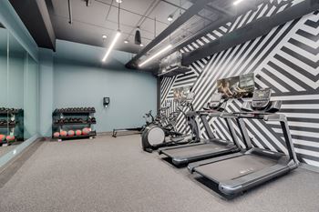a gym with treadmills and weights and a drum set